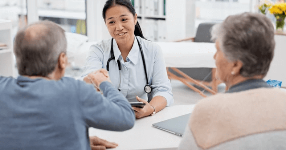 Una dottoressa che stringe la mano a due pazienti durante un incontro nel suo studio