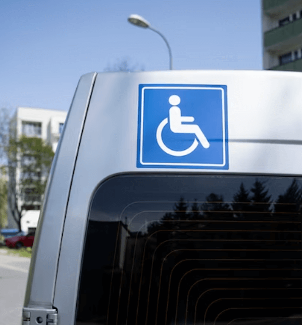 Primo piano del simbolo affisso sul mezzo di trasporto per segnalare un trasporto disabili